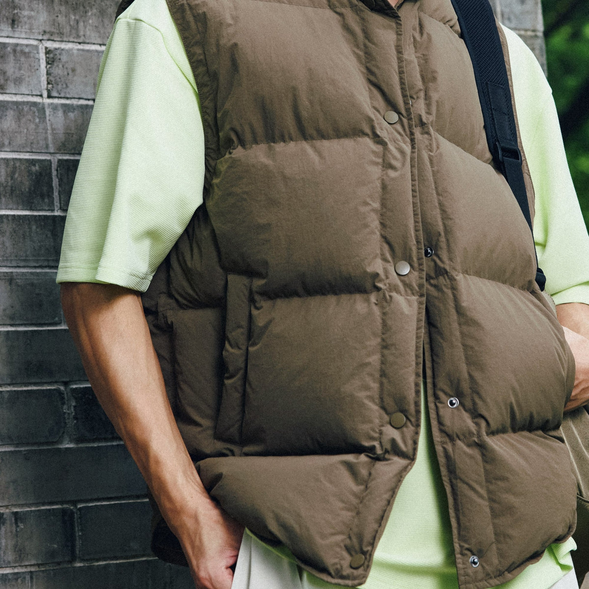 A bright yellow patch pocket tee under a quilted layer.
