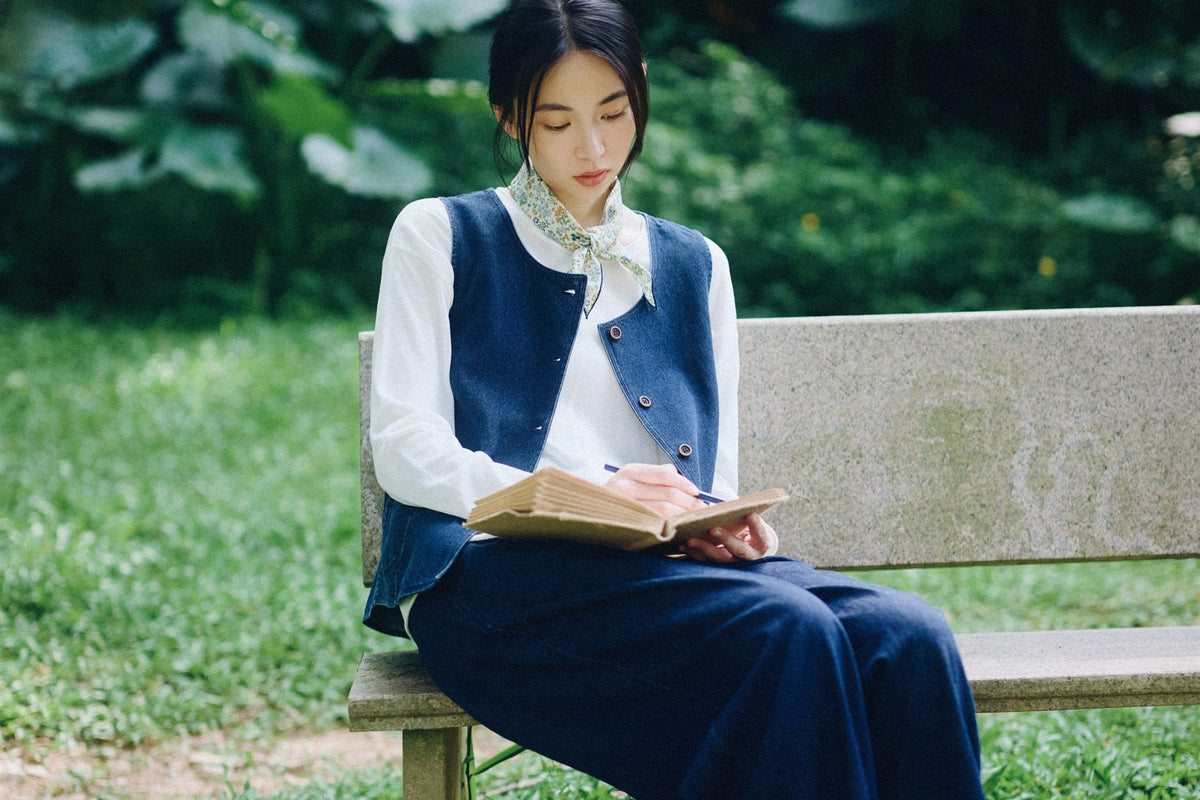 The denim patch pocket vest over a crisp cream blouse.