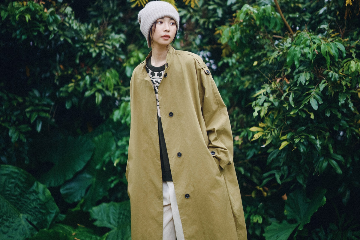 The patterned knit sweater over beige barrel trousers.
