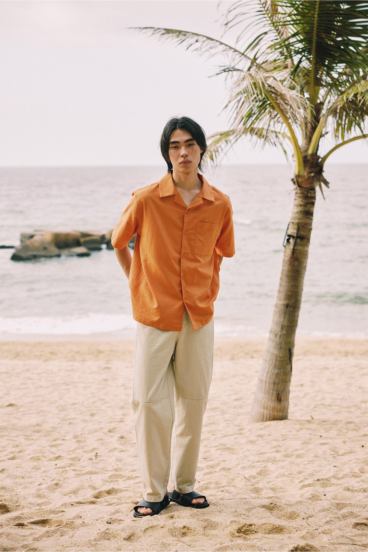 An open collar in washed orange, over a straight-leg beige.